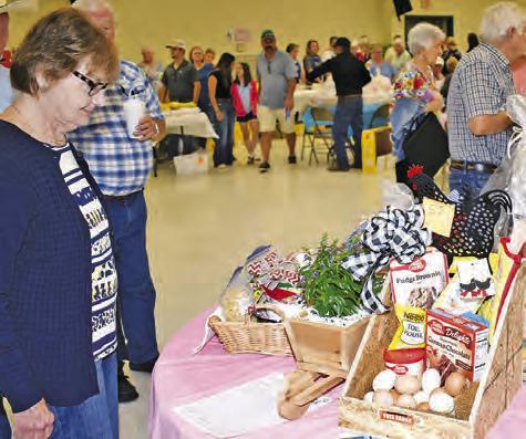 LOCAL RESIDENTS EXAMINED the auction items at the Saturday fundraiser benefitting the New Tabor Brethren Church.