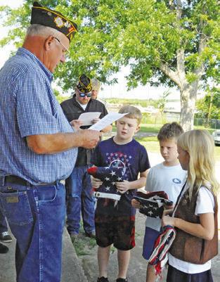 FRANKLIN KARASEK, VFW Post 4458 Post Service Officer, leads last Friday’s flag retirement service at the post. Area children presented three flags to retire by burning during the Friday morning ceremony.